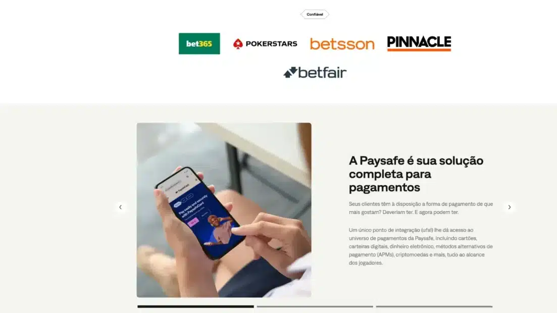 Seção do site da Paysafe com os logotipos de bet365, PokerStars, Betsson, Pinnacle e Betfair sob o selo Confiável e, abaixo, um celular com a tela do paysafecard ao lado do título A Paysafe é sua solução completa para pagamentos